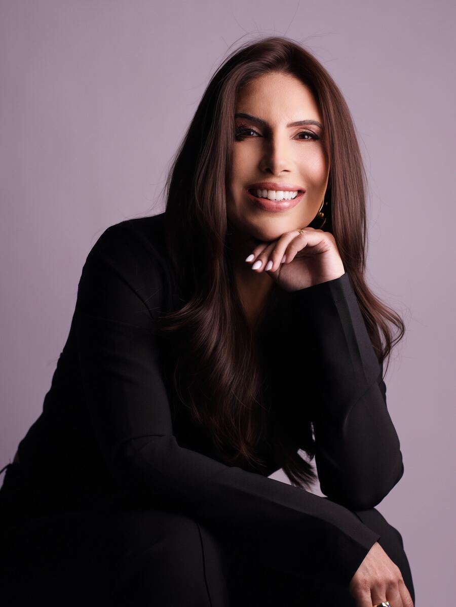 Dra. Andressa Cunha sorrindo, apoiada na mão